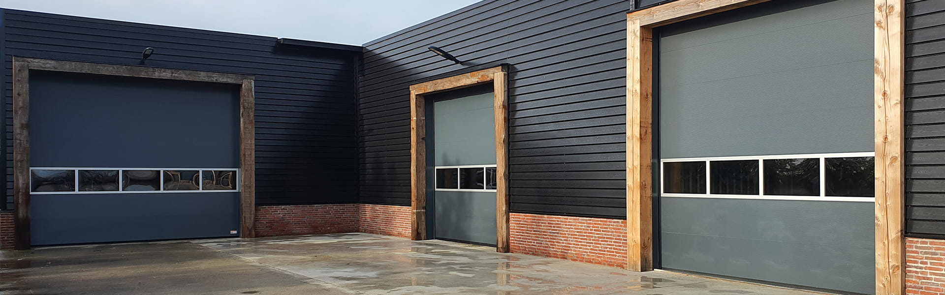 Industriedeuren bij bedrijfshal met meerdere overheaddeuren voor magazijn en loods